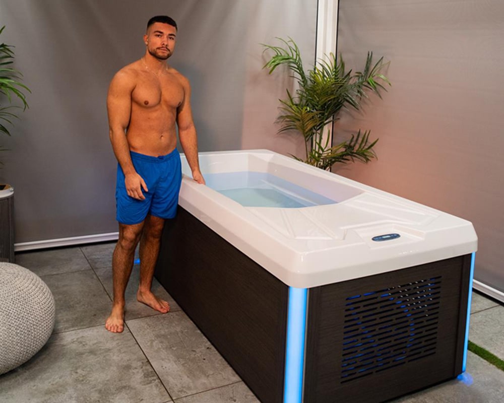 man standing next to a chill tub